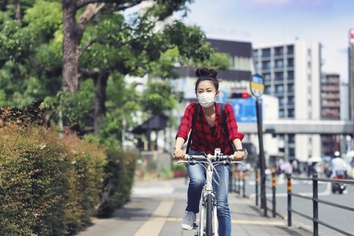 マスクをして自転車に乗る女性
